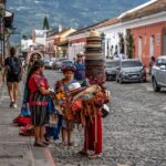 Indigenous women standing in a street in Guatemala with the mountains in the background