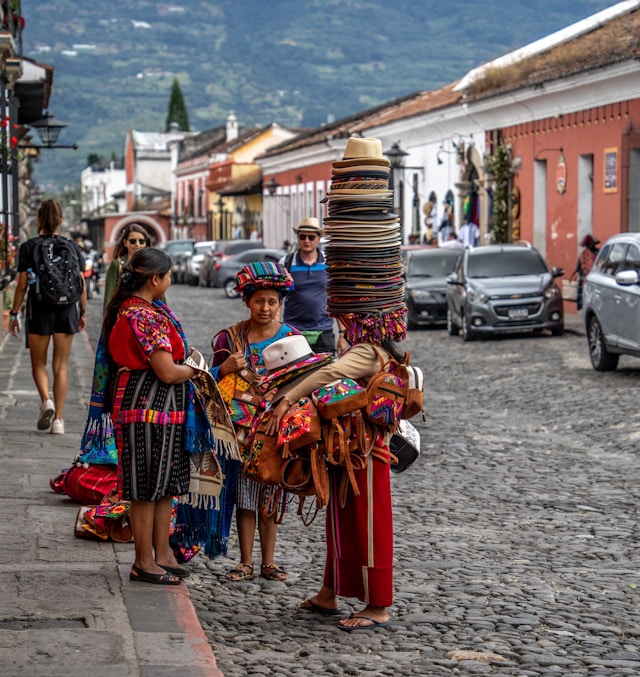 Indigenous women standing in a street in Guatemala with the mountains in the background